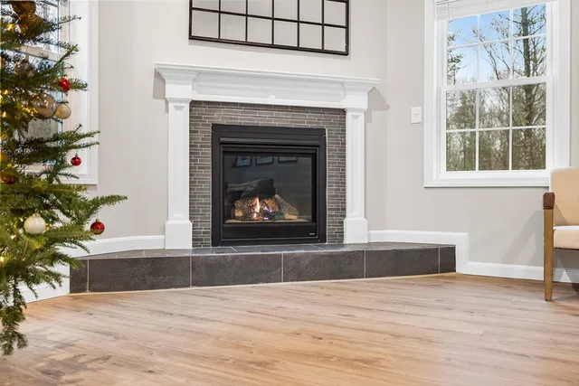a living room with a fireplace and wooden floor