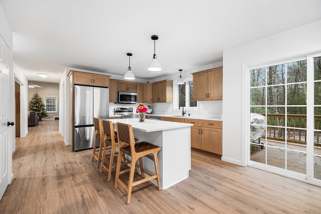 48 Walnut Street Douglas, MA 01516 - Photo 10 of 32 a kitchen with stainless steel appliances kitchen island granite countertop a refrigerator a stove a sink dishwasher and white cabinets with wooden floor