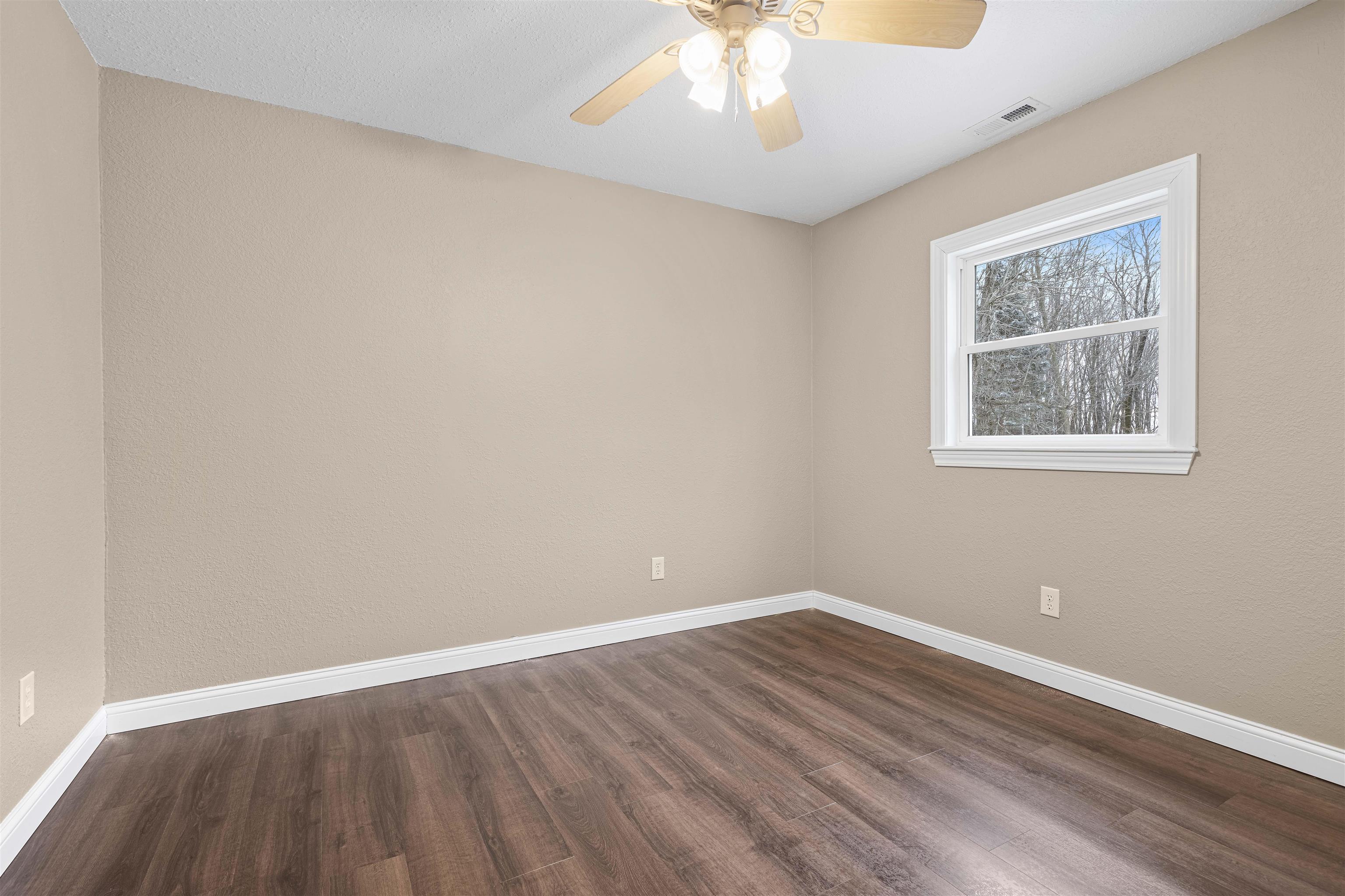 6872 Safford Road Rockford, IL 61101 - Photo 6 of 25 a view of an empty room with wooden floor and a window