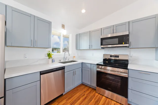 a kitchen with stainless steel appliances a stove sink microwave and cabinets