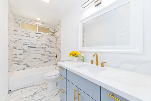 a bathroom with a sink a toilet and shower