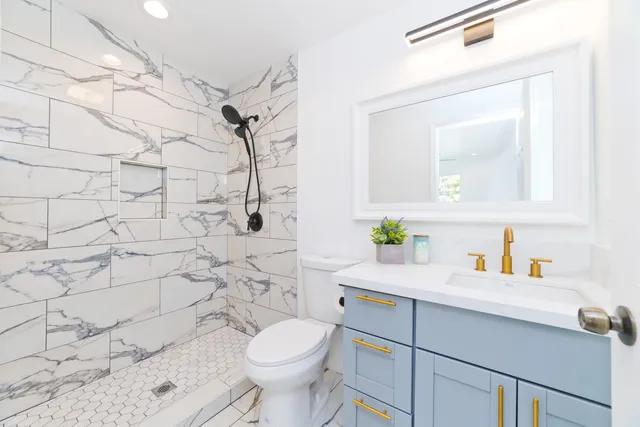a bathroom with a sink mirror vanity and toilet