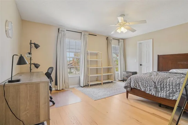 a spacious bedroom with a bed and a table chair