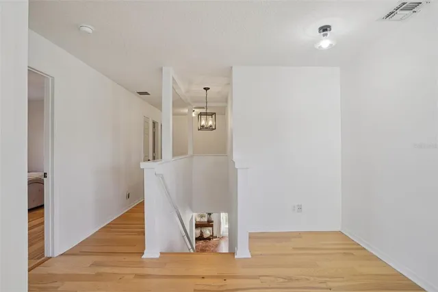 a view of a hallway with wooden floor and staircase