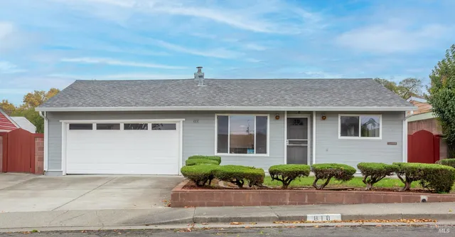 a front view of a house with a yard and potted plants