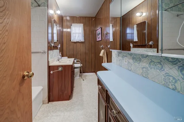 a bathroom with double vanity and a bathtub