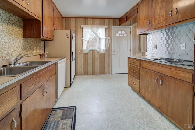 a kitchen with granite countertop a sink stove and cabinets