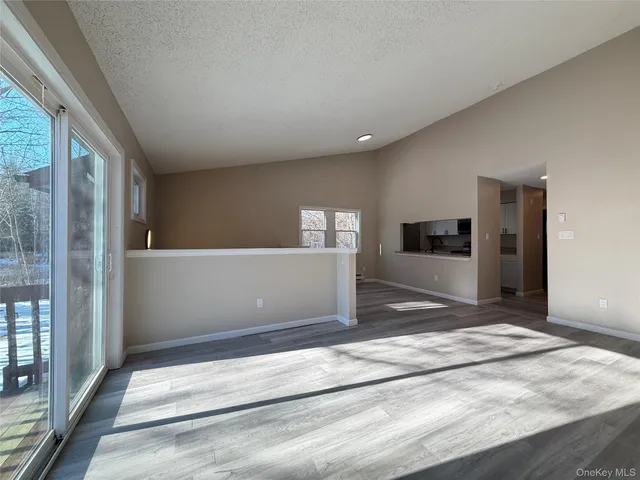 a view of a hallway with wooden floor and kitchen