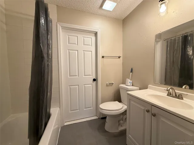 a bathroom with a granite countertop toilet a sink and a mirror