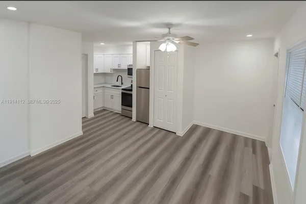 a view of a kitchen with a sink a refrigerator and window