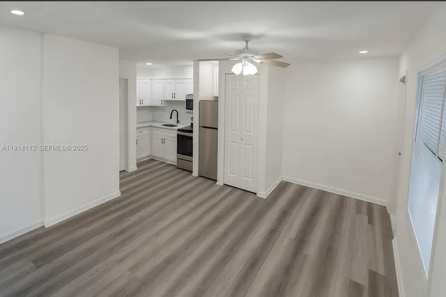 a view of a kitchen with a sink a refrigerator and window