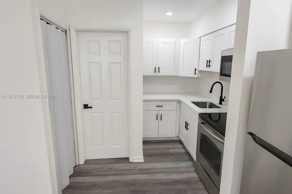 a kitchen with stainless steel appliances a refrigerator sink and cabinets