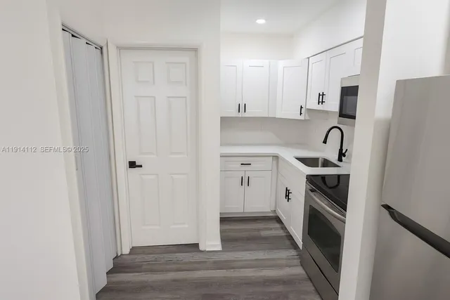 a kitchen with stainless steel appliances a refrigerator sink and cabinets