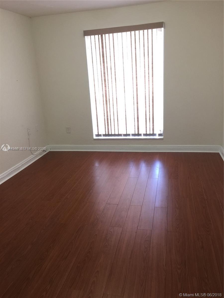 9403 Southwest 76th Street, Unit Y28 Miami, FL 33173 - Photo 11 of 20 an empty room with wooden floor and windows