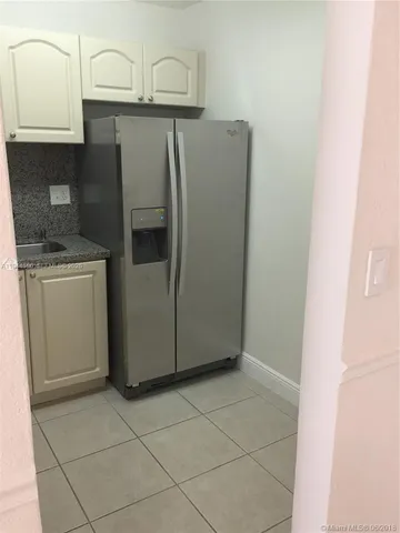 a metallic refrigerator freezer sitting in a kitchen