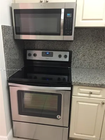 a stove top oven sitting inside of a kitchen
