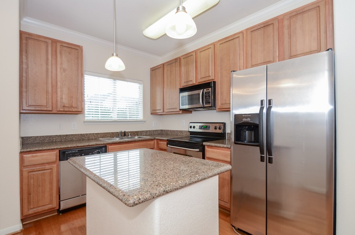 9200 Westheimer Road, Unit 802 Houston, TX 77063 - Photo 16 of 32 a kitchen with kitchen island granite countertop a sink appliances cabinets and counter space