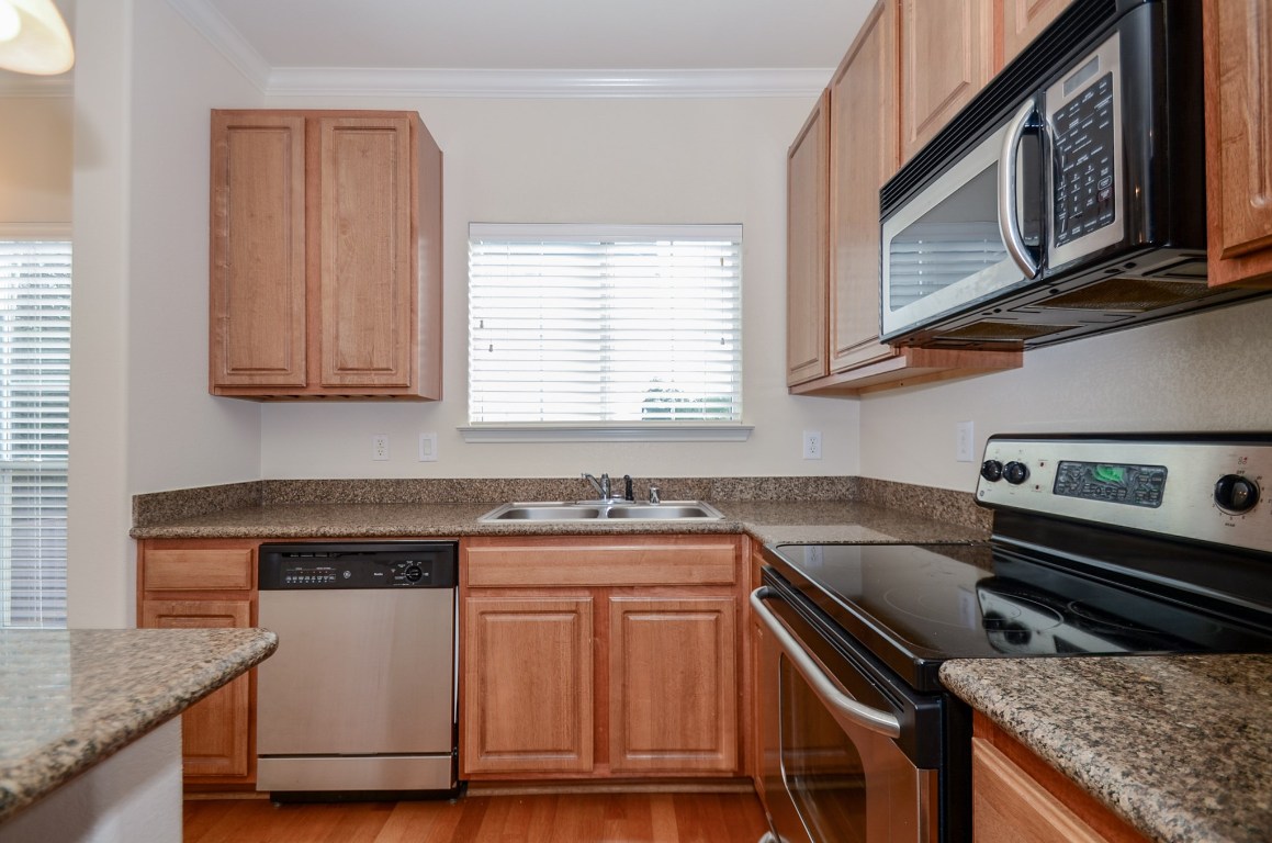 9200 Westheimer Road, Unit 802 Houston, TX 77063 - Photo 17 of 32 a kitchen with granite countertop a stove sink and microwave