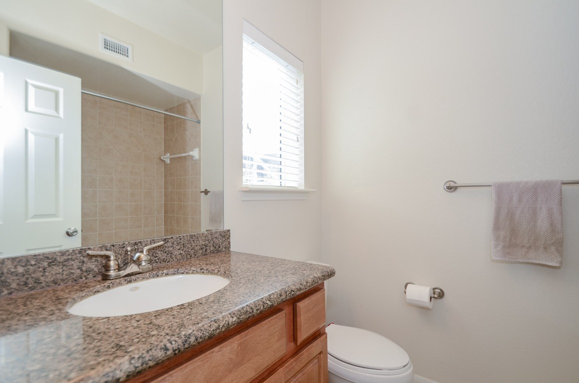 9200 Westheimer Road, Unit 802 Houston, TX 77063 - Photo 9 of 32 a bathroom with a granite countertop sink toilet and mirror