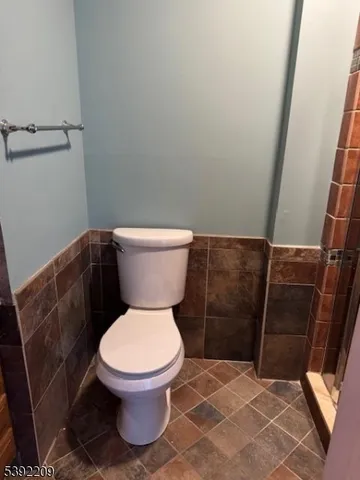 a white toilet sitting next to a shower