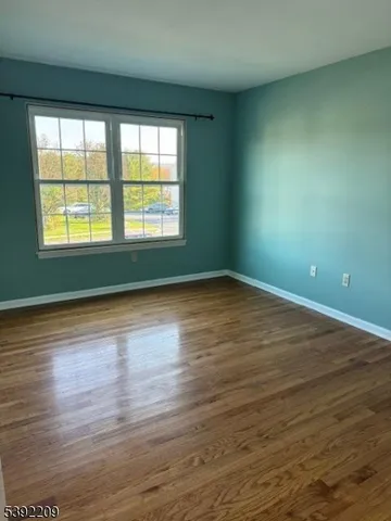 a view of room with window and wooden floor