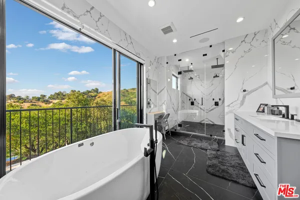 a bathroom with a sink a toilet a mirror and shower