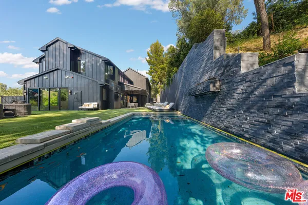 a view of a house with backyard and sitting area