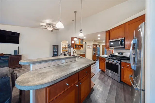 a kitchen with stainless steel appliances granite countertop a stove a sink and a refrigerator
