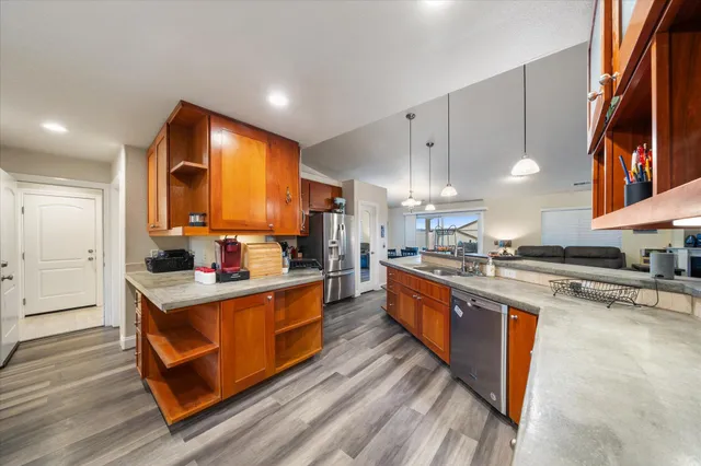 a kitchen with stainless steel appliances granite countertop a sink a stove and a refrigerator