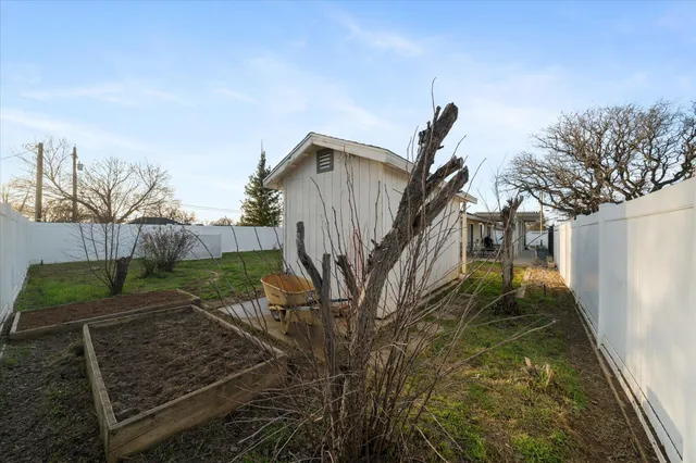 a view of a house with a yard and a large tree