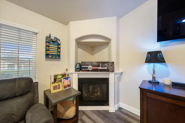 a living room with furniture kitchen view and a wooden floor