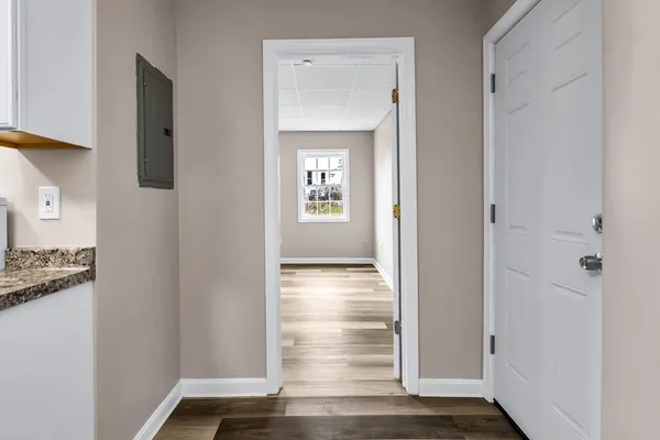 a view of a hallway with wooden floor and closet