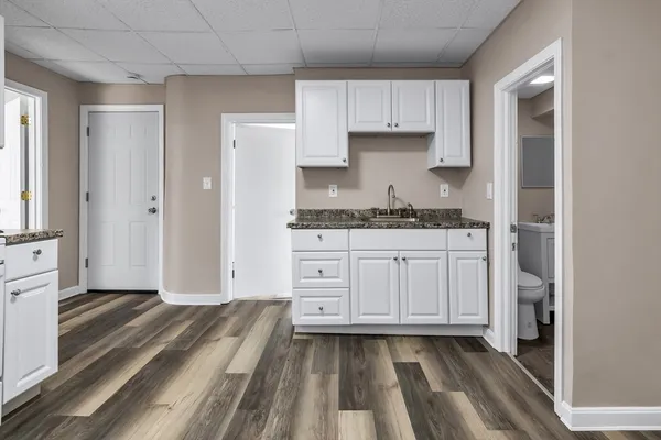 a kitchen with granite countertop a sink a stove and cabinets