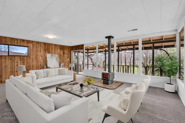 a living room with furniture and large window with outer view