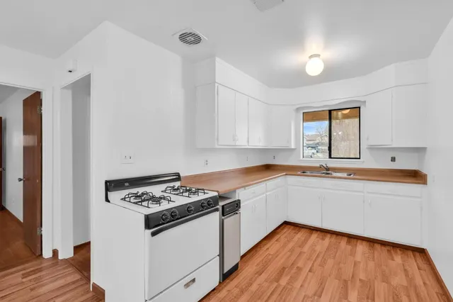 a kitchen with granite countertop a sink and a stove top oven