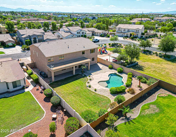 an aerial view of a house with a garden and lake view