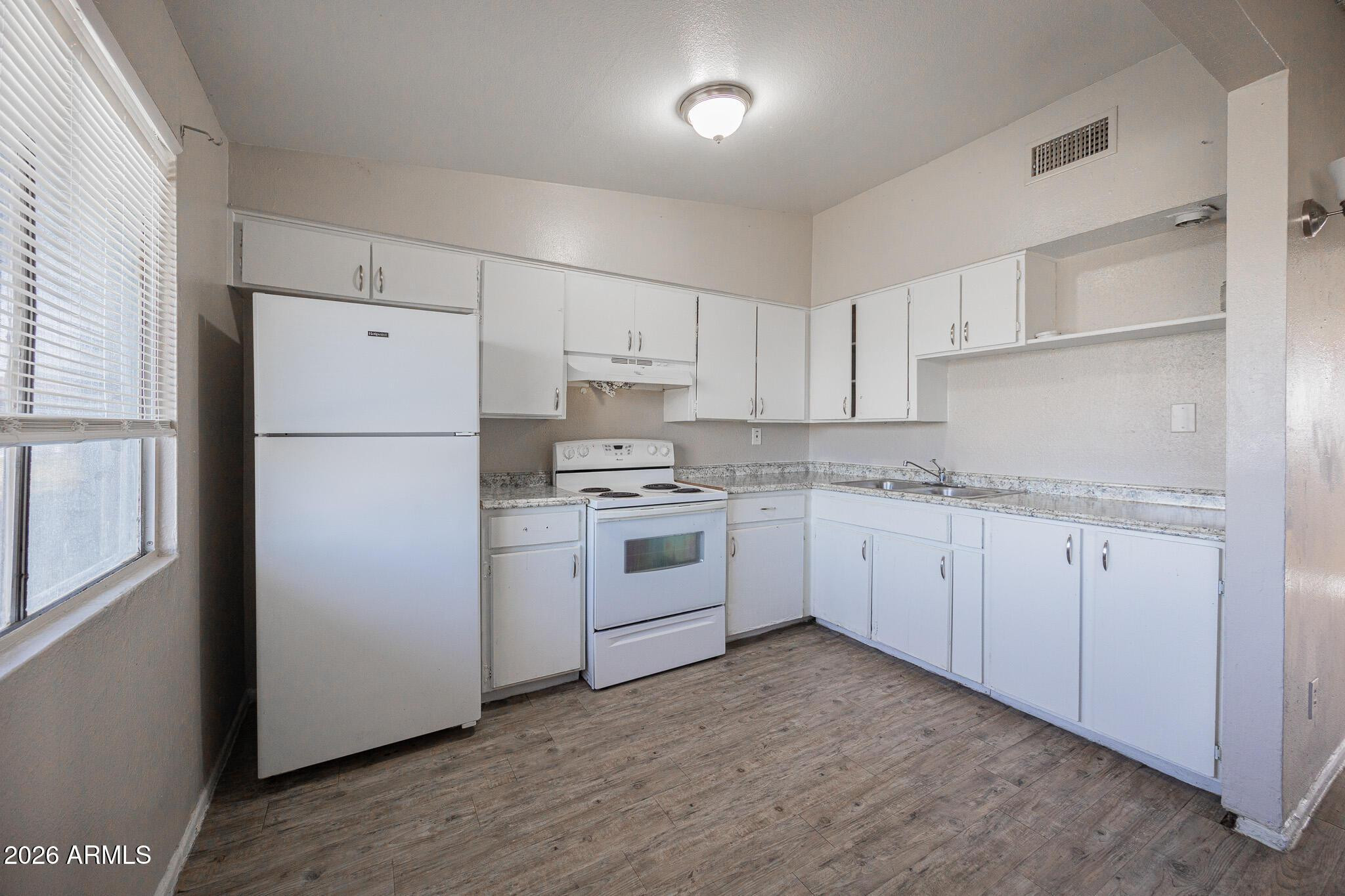 2123 West Devonshire Avenue, Unit 9 Phoenix, AZ 85015 - Photo 4 of 12 a kitchen with white cabinets white appliances and sink