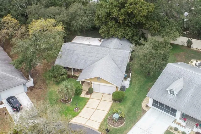 a view of a white house with a big yard and palm trees