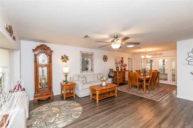 a dining room with furniture potted plants and wooden floor
