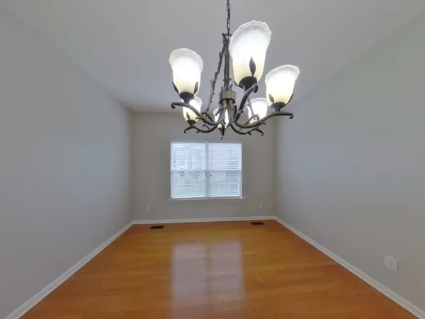 a view of a room with wooden floor and a bathroom