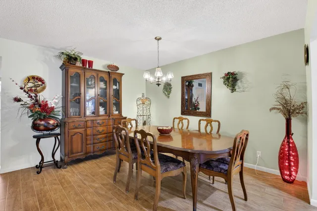 a dining room with furniture potted plants and wooden floor
