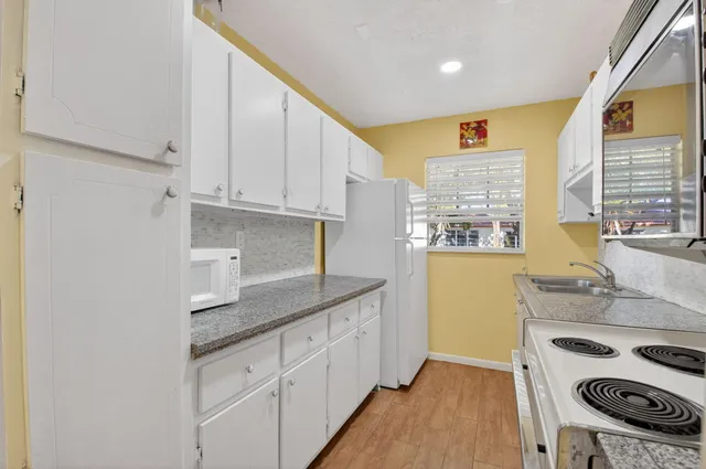 a kitchen with a sink stove and cabinets