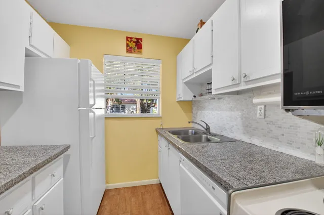 a kitchen with granite countertop a sink and a stove