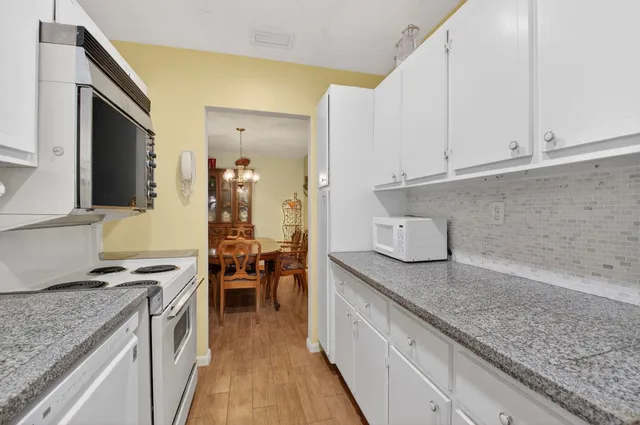 a kitchen with granite countertop a sink stove and cabinets