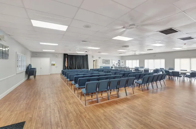 a view of a room with lots of wooden furniture and a chandelier