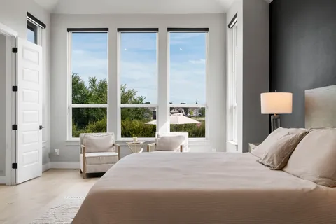 a bedroom with a bed and large window
