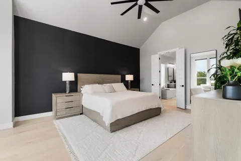 a bedroom with a large bed and a chandelier