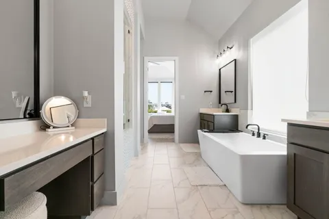 a en suite bathroom with a double vanity sink and a mirror