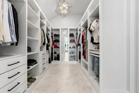 a view of walk in closet with clothes and shoes