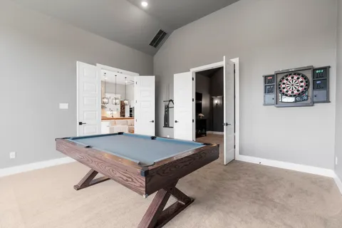 a room with pool table and windows
